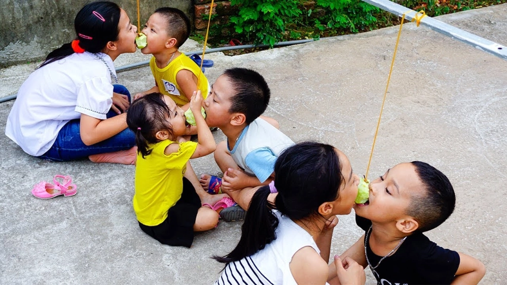 Khoảnh khắc vui nhộn với hình ảnh thi ăn táo trên dây lầy lội của các thành viên trong đội