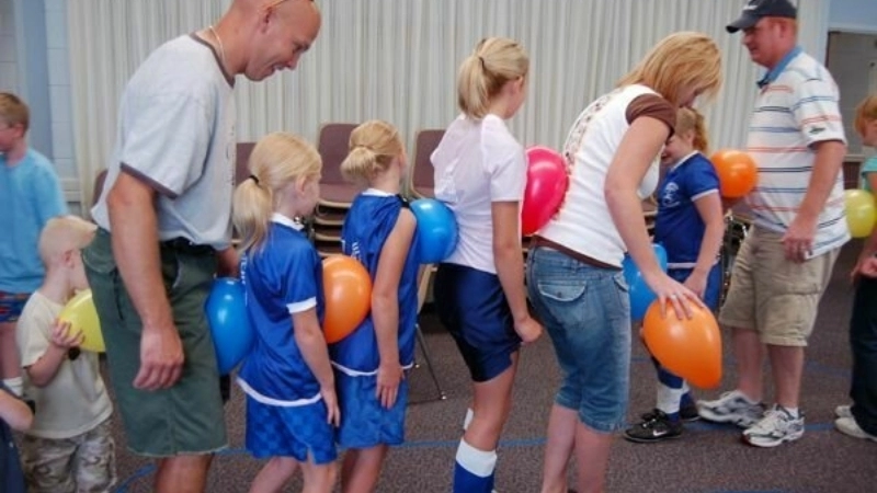 Thành viên hào hứng tham gia trò chơi vận động kẹp bóng trong chương trình dã ngoại