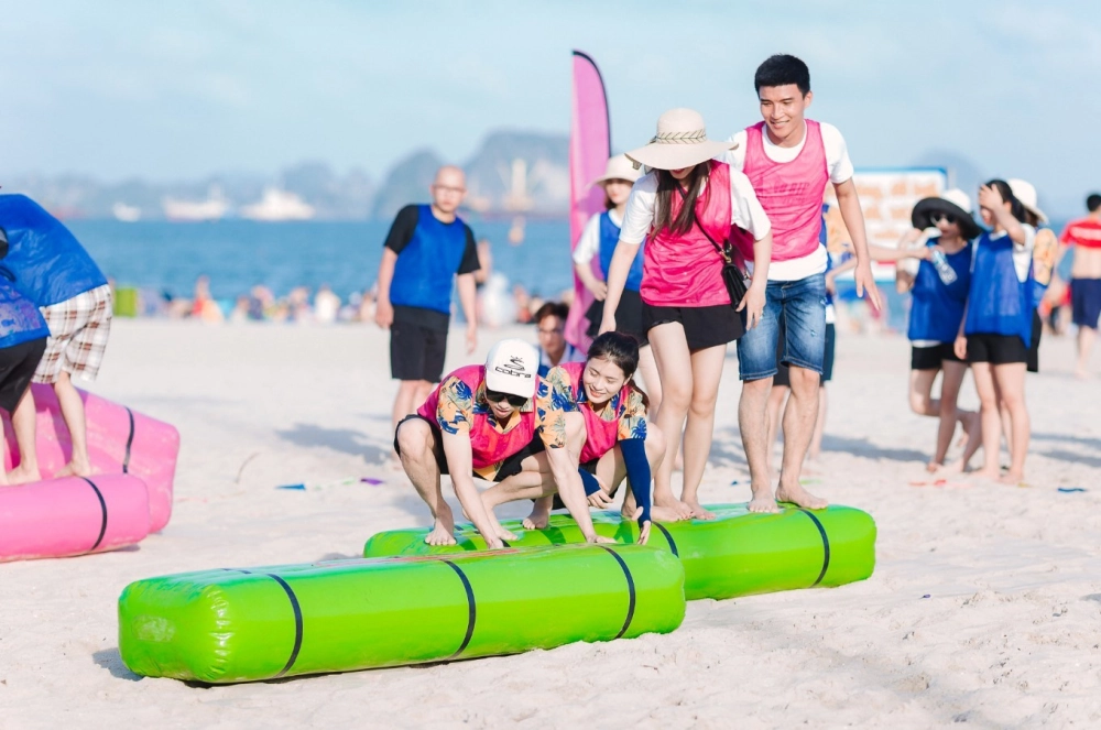 Người chơi đang chạy đua trên cát trắng trong một chương trình du lịch hè sôi động